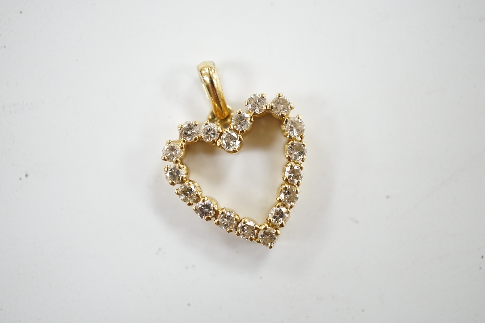 A modern 18k and diamond cluster set open work heart shaped pendant, overall 21mm, gross weight 2.7 grams. Condition - fair to good